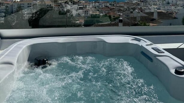 A hot tub with a clear view of a coastal town and the sea. - Malpique Guest House & Jacuzzi (Albufeira)