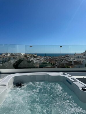A hot tub with a clear view of a coastal town and the sea. - Malpique Guest House & Jacuzzi (Albufeira)