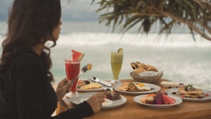 A table with various dishes and drinks, overlooking a body of water. - Umarimba Beach Lodge (Mertak)