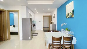 A modern hotel room with a dining area, a kitchen, and a bedroom. - Ocean View Home Danang (Da Nang)
