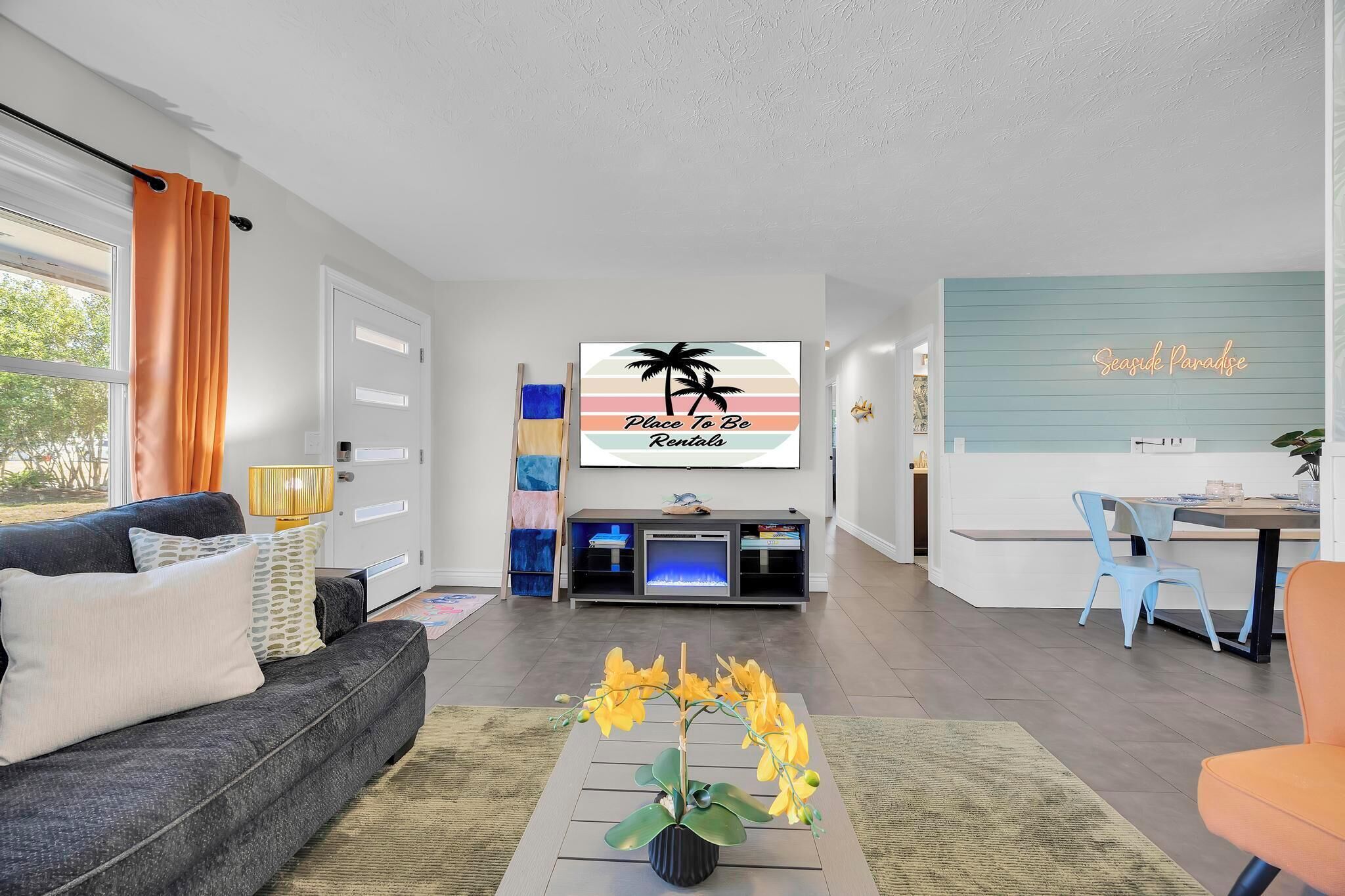 A modern living room with a sofa, coffee table, and a TV displaying 'Place To Be Rentals'.