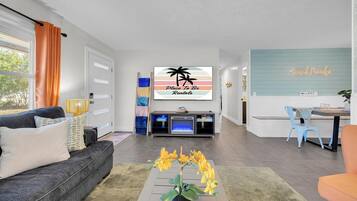 A modern living room with a sofa, coffee table, and a TV displaying 'Place To Be Rentals'.
