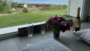 Ein Balkon mit Blick auf das Meer, eine Champagnerflasche und eine Blumenvase.