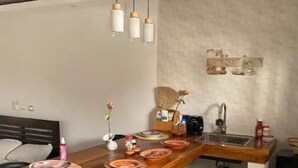 A compact kitchen with a wooden countertop, a sink, and a small dining area.