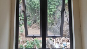 Una ventana con vista a un área boscosa.