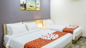 Habitación de hotel con dos camas, aire acondicionado de pared y un cuadro con un velero y un delfín.