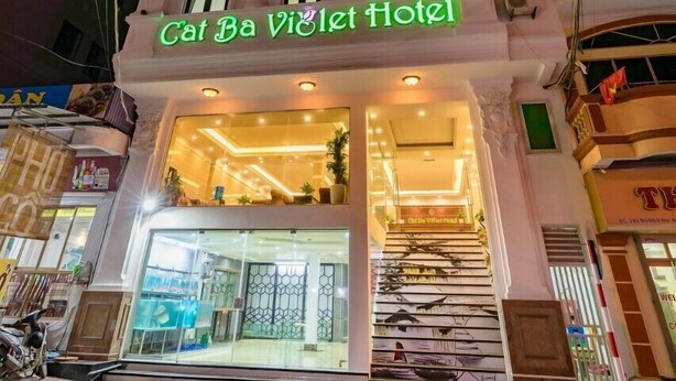 Entrada de un hotel con un cartel que dice 'Cat Ba Viêt Hotel'.