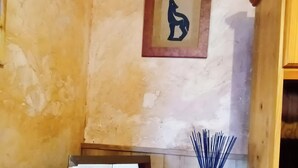 Um quarto com um armário de madeira, um quadro na parede e um livro sobre uma mesa.
