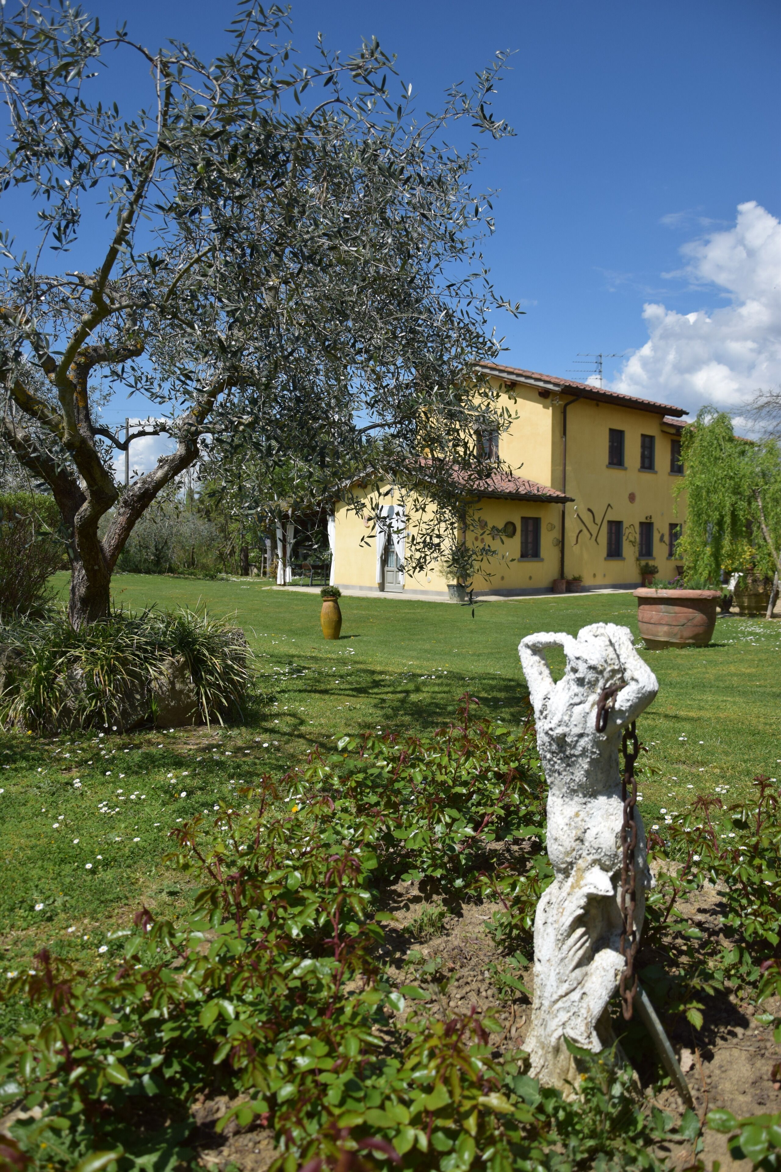 A yellow building with a garden in front.