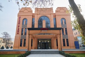 A brick building with a large arched entrance, labeled "Grand Plaza Hotel" and "HOTEL" above the doors. - Reikartz Grand Samarkad (Samarkand)
