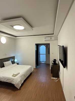 Escritorio, tabla de planchar con plancha y ropa de cama 