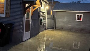 A residential property with a garage, a wooden door, and a concrete driveway.