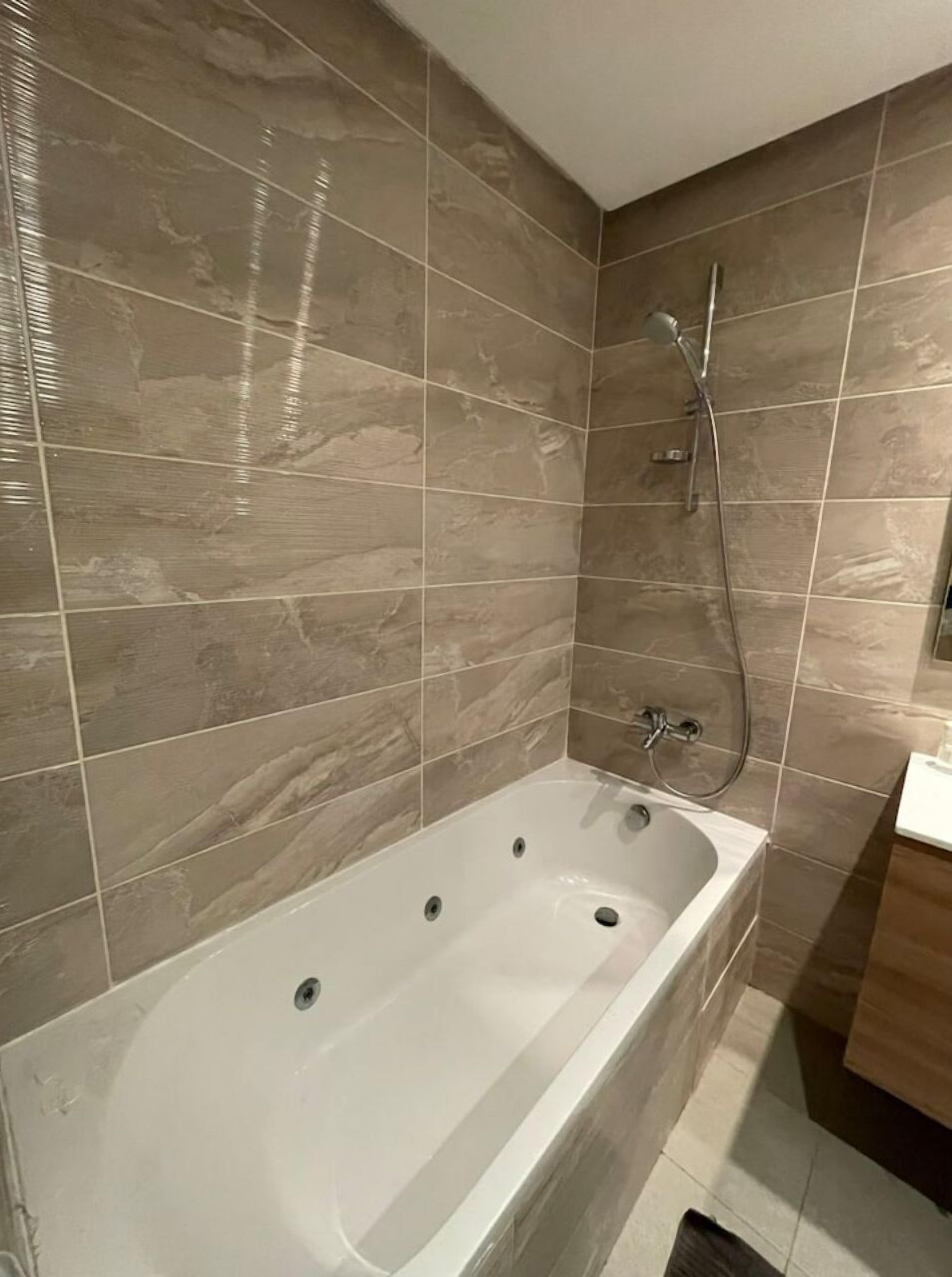 A modern bathroom with a freestanding bathtub, a shower area, and a sink.