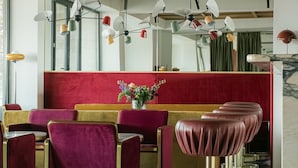 A restaurant with red velvet booths, gold chairs, and a marble floor. - Castor & Pollux Hotel (Tbilisi)