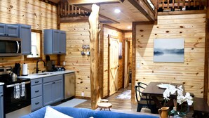 A cozy cabin interior with a kitchen, dining area, and a living space.