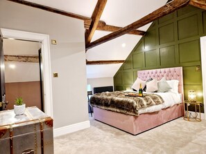 A bedroom with a large bed, a dresser, and a mirror.
