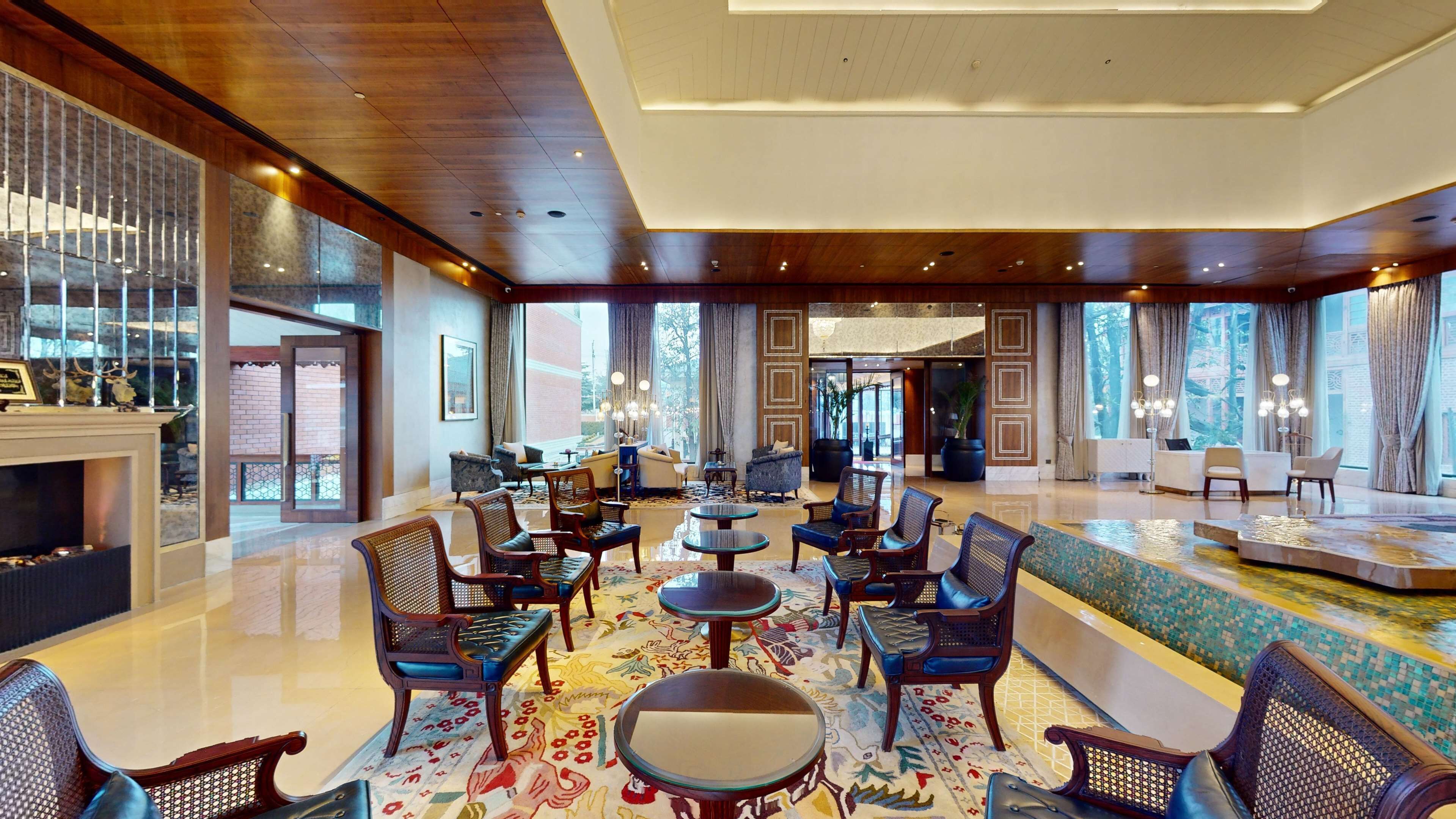 A spacious lobby with a central seating area, a fireplace, and large windows offering views.