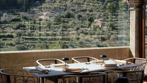 A terrace with tables and chairs, overlooking a terraced vineyard. - Valldemossa Hotel (Valldemossa)
