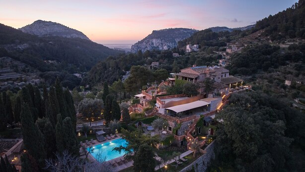 A hillside villa with a swimming pool, terraced gardens, and a view of the surrounding mountains. - Valldemossa Hotel (Valldemossa)