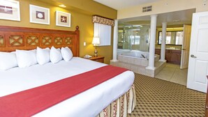 A hotel room with a large bed, a bathroom with a bathtub, and a view of the hallway. - Escape to Our Resort in Orlando,s Entertainment Hub Near Theme Parks & Shopping! (Orlando)