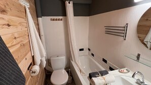 A bathroom with a toilet, bathtub, and sink.