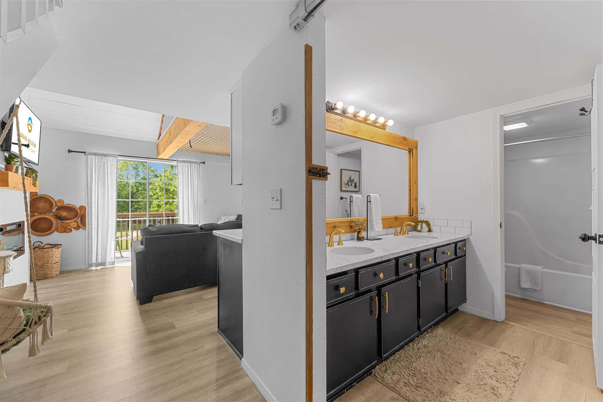 A modern bathroom with a large mirror, vanity, and a shower.
