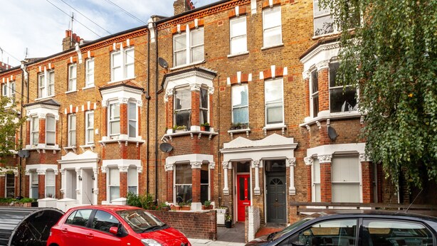 A row of terraced houses with a red car parked in front. - The Westbourne Park Collection (London)