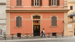 A multi-story building with a consistent architectural style, featuring a central entrance with a door and windows with shutters.