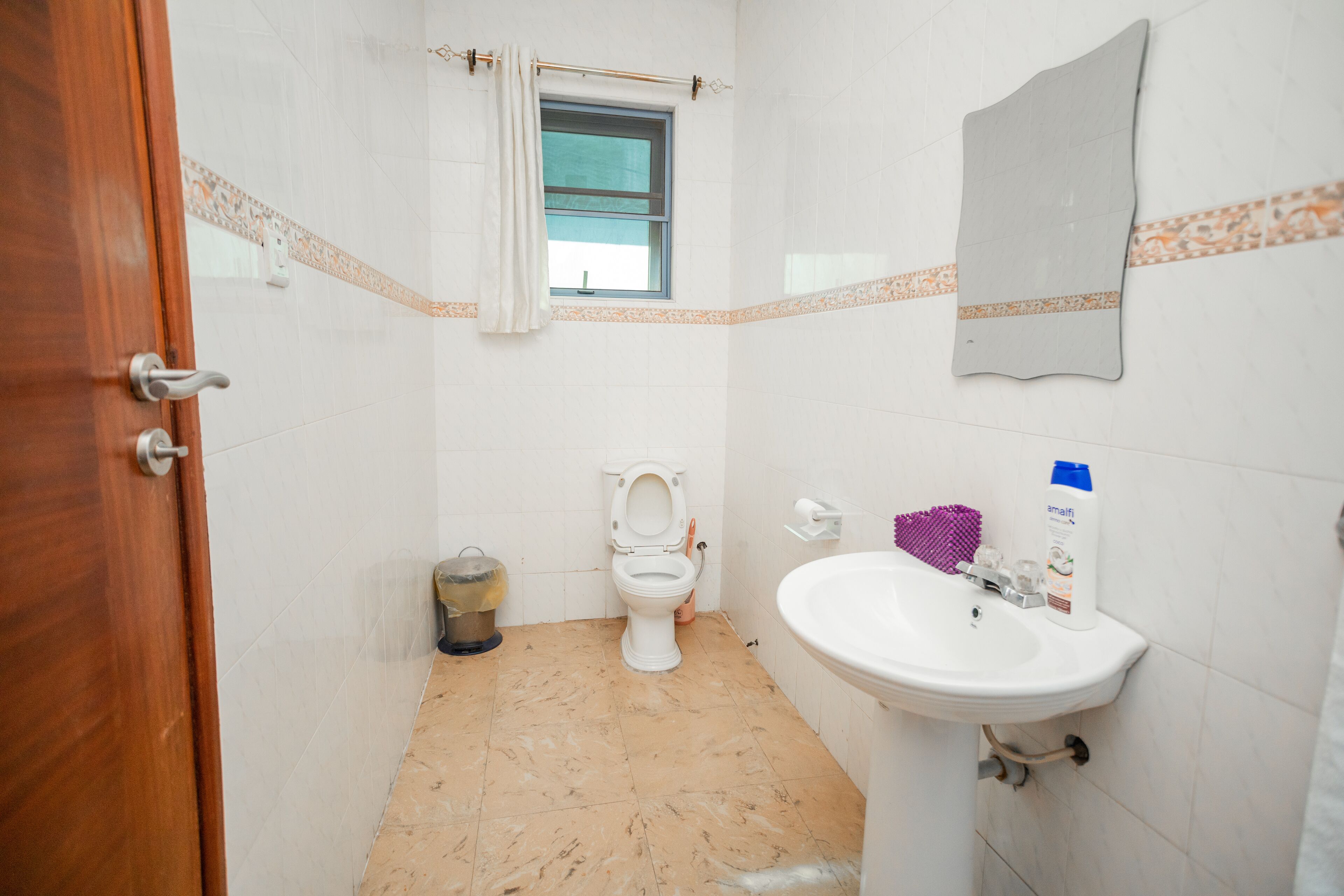 Un baño con inodoro, lavamanos y ventana.