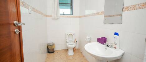Un baño con inodoro, lavamanos y ventana.