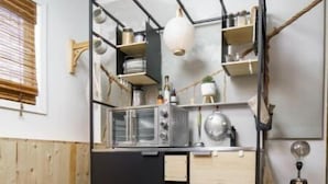 Eine kompakte Küche mit Schwarz-Weiß-Farbgestaltung, Holzschränken und einem runden Teppich auf dem Boden.