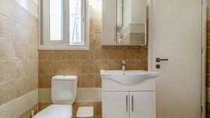 A bathroom with a toilet, sink, and cabinet. - Alex Home by Corfuescapes (Corfu)