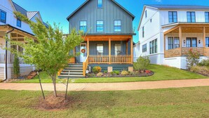 A two-story house with a front porch, a small tree, and a well-maintained lawn. - New Property in Carlton Landing-Nolan's Nook- Pet Friendly (Carlton Landing)