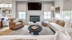 A modern living room with a fireplace, two sofas, a coffee table, and a TV mounted on the wall. - New Property in Carlton Landing-Nolan's Nook- Pet Friendly (Carlton Landing)