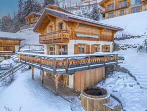A wooden chalet with a balcony and a hot tub. - Chalet Sapin Argenté (Riddes)