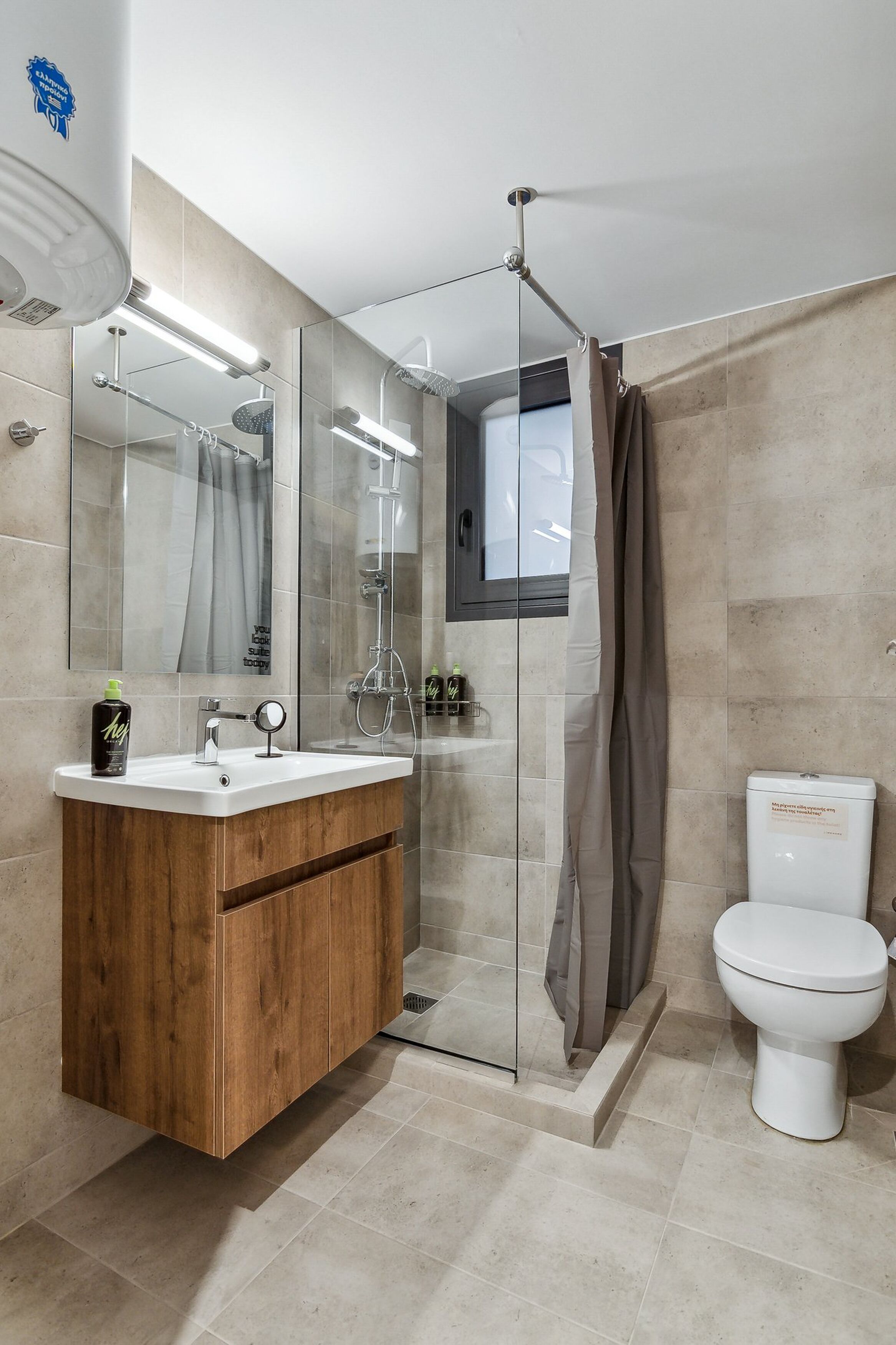 A modern bathroom with a wooden vanity, a glass shower enclosure, and a white toilet.
