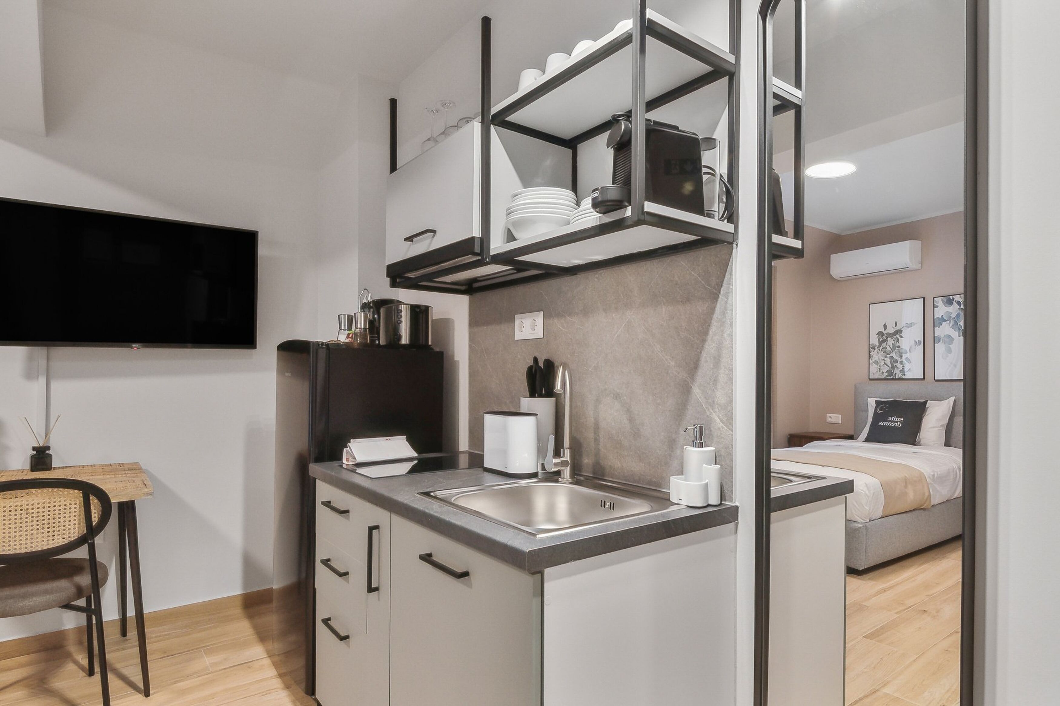 Une petite cuisine équipée, avec une cuisinière intégrée, un évier et un coin repas comprenant une chaise.