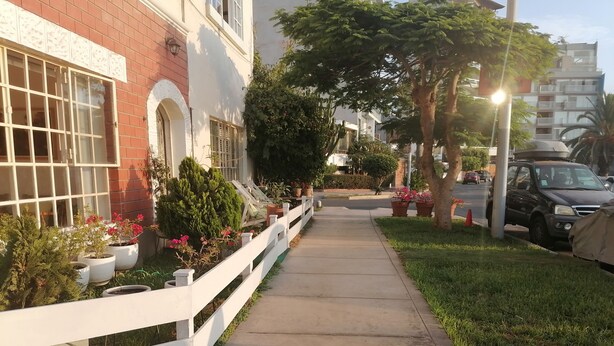 A sidewalk lined with potted plants and a white fence. - Beautiful beachfront apartment a few minutes from the best Limeña beaches (Ciudad de Guatemala)