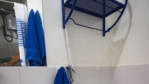 A bathroom with a white sink, a toilet, a blue towel, and a shower. - Beautiful beachfront apartment a few minutes from the best Limeña beaches (Ciudad de Guatemala)