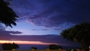 A sunset over a coastal area with palm trees and a clear sky. - Beautiful beachfront apartment a few minutes from the best Limeña beaches (Ciudad de Guatemala)