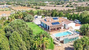 Ein Wohnhaus mit Swimmingpool, Solaranlage und großem Garten.