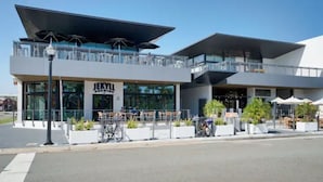 A modern building with a glass facade, outdoor seating, and a bike parking area. - Ocean Seaside Escape B
 (Jacksonville Beach)
