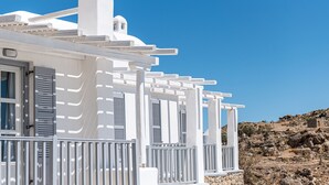 Un bâtiment blanc avec un balcon et un mur de pierre en arrière-plan.