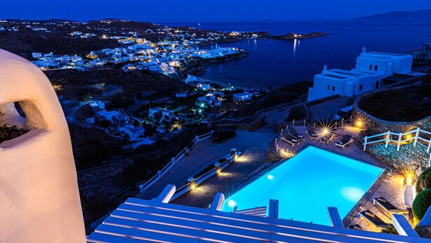 Un complexe hôtelier doté d’une piscine, de bâtiments blancs et offrant une vue sur la mer.