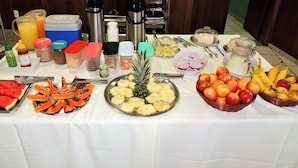 A buffet table with various fruits, condiments, and beverages. - Bom Despacho (Bom Despacho)