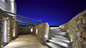 Una scala in pietra conduce a un edificio moderno con struttura a copertura in metallo.