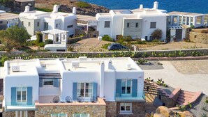Un hotel sul lungomare con piscina, area salotto all'aperto e vista mare.
