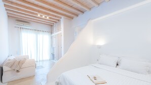 Une chambre moderne avec un grand lit, un canapé et une fenêtre avec des rideaux.