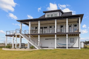 A two-story house with a covered porch, a staircase, and a large garage.