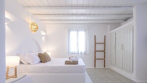 Une chambre à coucher avec un lit, une table de chevet, une lampe, une armoire et une fenêtre.